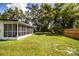 The backyard features a fenced-in yard, a screened-in porch and mature trees at 4629 Harden Blvd, Lakeland, FL 33813