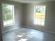Bedroom featuring new flooring, two windows, and neutral color scheme at 4629 Harden Blvd, Lakeland, FL 33813