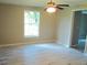 Bedroom featuring a ceiling fan, new flooring, a large window, and neutral color scheme at 4629 Harden Blvd, Lakeland, FL 33813