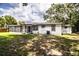 The home's exterior showcases a screened-in porch and verdant yard with mature trees at 4629 Harden Blvd, Lakeland, FL 33813