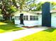 View of the home's entrance, showcasing a bright, window-lined porch and a striking black brick chimney at 4629 Harden Blvd, Lakeland, FL 33813