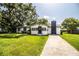 Charming single-story home with white exterior, black trim, chimney, and lush green lawn at 4629 Harden Blvd, Lakeland, FL 33813