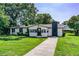 Charming single-story home with white exterior, black trim, chimney, and lush green lawn at 4629 Harden Blvd, Lakeland, FL 33813