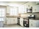 Renovated kitchen with white cabinets, stainless steel appliances, granite countertops, and view to backyard at 4629 Harden Blvd, Lakeland, FL 33813