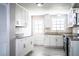 Bright kitchen featuring white cabinets, stainless steel appliances, gray tile flooring, and granite countertops at 4629 Harden Blvd, Lakeland, FL 33813