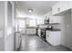 Bright kitchen features white cabinets, stainless steel appliances, granite countertops, and gray tile flooring at 4629 Harden Blvd, Lakeland, FL 33813