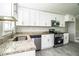 Bright kitchen featuring white cabinets, stainless steel appliances, gray tile flooring, and granite countertops at 4629 Harden Blvd, Lakeland, FL 33813