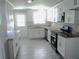 Updated kitchen featuring stainless steel appliances, tile flooring, granite countertops, and white cabinetry at 4629 Harden Blvd, Lakeland, FL 33813