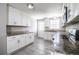 Well-lit kitchen with white cabinets, granite countertops, and stainless steel appliances, and gray tile flooring at 4629 Harden Blvd, Lakeland, FL 33813