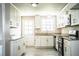 Bright kitchen featuring white cabinets, stainless steel appliances, gray tile flooring, and granite countertops at 4629 Harden Blvd, Lakeland, FL 33813