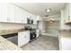 Modern kitchen boasts white cabinets, stainless steel appliances, granite countertops, with open view to living area at 4629 Harden Blvd, Lakeland, FL 33813