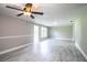 Open-concept living room with ceiling fan, natural light, base-trim molding, and marble tile flooring at 4629 Harden Blvd, Lakeland, FL 33813