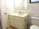 Cozy bathroom features a toilet, a sink, vanity with storage and mirror at 5070 Ironwood Trl, Bartow, FL 33830
