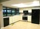 Bright kitchen featuring tile floors, modern appliances, and a window overlooking a green yard at 5070 Ironwood Trl, Bartow, FL 33830