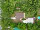 An aerial view of the home with mature trees, backyard pool, and driveway at 5120 Lunn Rd, Lakeland, FL 33811