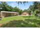 Spacious backyard featuring a well-maintained lawn, an outbuilding, and a charming brick house at 5120 Lunn Rd, Lakeland, FL 33811