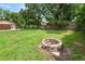Expansive backyard features a fire pit and mature trees, creating a serene outdoor space at 5120 Lunn Rd, Lakeland, FL 33811