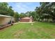 Spacious backyard with a brick outbuilding, surrounded by lush greenery and privacy fencing at 5120 Lunn Rd, Lakeland, FL 33811
