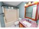 This bathroom features a tub and shower combo, wood mirror, and updated vanity at 5120 Lunn Rd, Lakeland, FL 33811