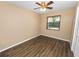 Bedroom includes a ceiling fan, wood-look flooring, and a window with natural light at 5120 Lunn Rd, Lakeland, FL 33811