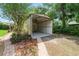 Exterior showcasing an open carport with ceiling fan with landscaped surroundings and brick pathway at 5120 Lunn Rd, Lakeland, FL 33811