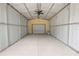 Carport interior featuring high ceilings, a ceiling fan, and roll up garage door at 5120 Lunn Rd, Lakeland, FL 33811