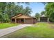 Cozy one-story brick home featuring an attached garage, long driveway and a detached, gated carport for additional covered parking at 5120 Lunn Rd, Lakeland, FL 33811
