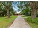 Single-story brick house with a long driveway, garage, and mature shade trees at 5120 Lunn Rd, Lakeland, FL 33811