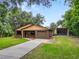 Charming brick home featuring an attached garage and separate carport, surrounded by a lush green lawn at 5120 Lunn Rd, Lakeland, FL 33811