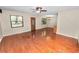 Open-concept living room featuring hardwood floors, ceiling fan, and seamless flow to the dining and kitchen areas at 5120 Lunn Rd, Lakeland, FL 33811