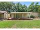 Well-kept outbuilding with a metal roof, two roll-up doors, and a covered porch at 5120 Lunn Rd, Lakeland, FL 33811