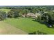 Aerial view of expansive property with a red metal roof, outbuildings, and a lush green yard at 5140 Alderman Rd, Lakeland, FL 33810