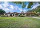 Ranch style home with a red metal roof, a covered car port, and a well-maintained lawn at 5140 Alderman Rd, Lakeland, FL 33810