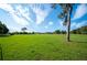 A sprawling green field stretches towards the horizon under a bright, partly cloudy sky at 5140 Alderman Rd, Lakeland, FL 33810