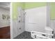 Barrier free bathroom featuring a sleek, accessible shower with white textured tile, black mosaic floor, and safety bars at 545 Prado Pl, Lakeland, FL 33803