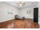 Cozy bedroom featuring warm wood floors, a ceiling fan, natural light from two windows, and a modern black wardrobe at 545 Prado Pl, Lakeland, FL 33803