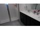 Bathroom featuring a glass-enclosed shower, dark vanity, and well-lit mirror, offering a clean and modern aesthetic at 550 Patton Loop, Bartow, FL 33830