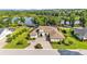 Stunning aerial view of an estate home with well-manicured grounds, circular driveway, and lake view at 6475 Avalon Woods Dr, Lakeland, FL 33813