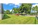 A lush backyard with a playset, mature trees, and lake views at 6475 Avalon Woods Dr, Lakeland, FL 33813