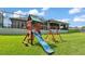 A great blue and red backyard playset with climbing and swinging activities on a green lawn at 6475 Avalon Woods Dr, Lakeland, FL 33813
