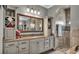 Bathroom with granite countertops, storage shelves, and tiled shower at 6475 Avalon Woods Dr, Lakeland, FL 33813