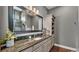Bathroom vanity with granite counters, large mirror, and storage at 6475 Avalon Woods Dr, Lakeland, FL 33813