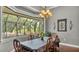 Dining room featuring a large window with views of the outdoor scenery and a chandelier at 6475 Avalon Woods Dr, Lakeland, FL 33813