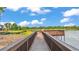 Picturesque view from the wooden walkway leading to the dock on the lake, surrounded by lush green landscape at 6475 Avalon Woods Dr, Lakeland, FL 33813