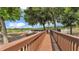 Picturesque lake view with a long wooden dock, surrounded by lush trees and clear blue skies at 6475 Avalon Woods Dr, Lakeland, FL 33813