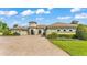 Charming single-Gathering home boasting lush landscaping, a turret entry, and a paver driveway at 6475 Avalon Woods Dr, Lakeland, FL 33813