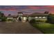 Exterior view of a single-Gathering home with a turret entry, paver driveway, and sunset sky at 6475 Avalon Woods Dr, Lakeland, FL 33813