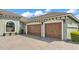 Spacious three-car garage with beautiful wooden doors, providing ample parking and storage at 6475 Avalon Woods Dr, Lakeland, FL 33813
