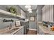 Well-lit laundry room with granite countertops, gray cabinets, stacked washer/dryer, and decorative accents at 6475 Avalon Woods Dr, Lakeland, FL 33813