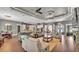 Spacious living room with hardwood floors, tray ceilings, ceiling fans, and a stone fireplace at 6475 Avalon Woods Dr, Lakeland, FL 33813
